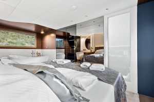 Luxuriously appointed guest cabin aboard motor yacht Bella featuring contemporary design and comfortable bedding.