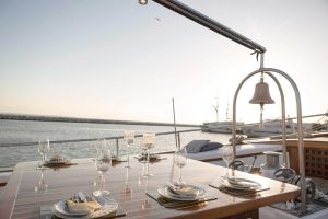 Expansive wooden sun deck and shaded alfresco dining lounge aboard charter gulet Cosmos.