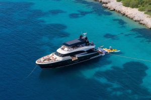Guests enjoying water sports and Seabob rides in a quiet cove with Bella Luna motor yacht anchored in the background.