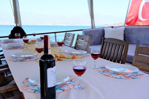 Large open-air dining table and comfortable seating area on the aft deck of luxury Gulet Esmeralda.