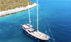 Side view of luxury wooden gulet Little Gulmaria anchored in Fethiye harbor on blue waters